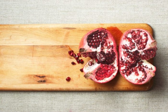 Cut pomegranate on the cutting board.